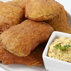 Five Mini Square Potato Snackers are served on a white plate with a small square dish of grainy mustard dip, garnished with a sprig of herb.